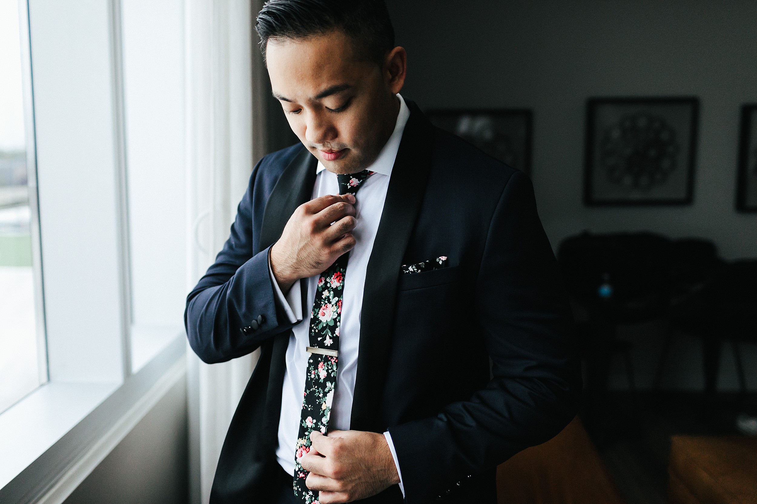 groom getting ready with floral tie